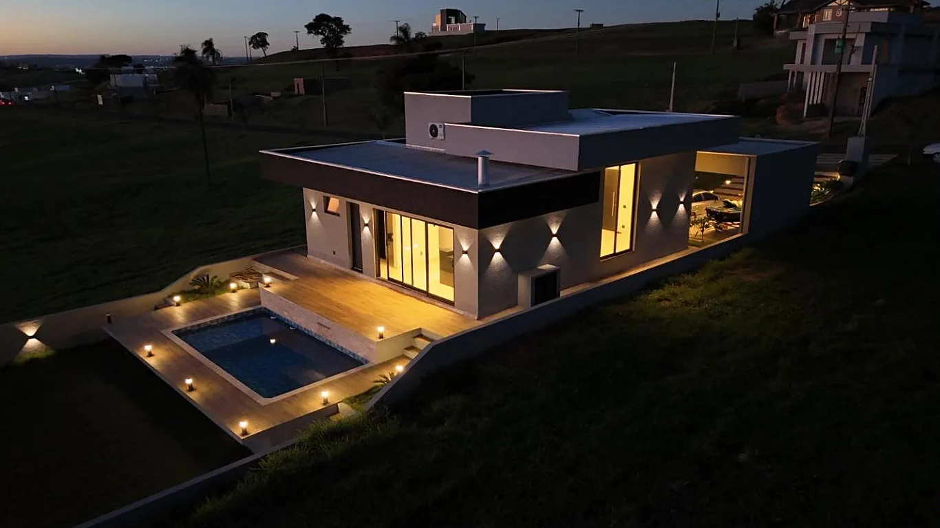 Casa térrea com piscina iluminada ao anoitecer, entregue pela Bonavita no Riviera de Santa Cristina XIII