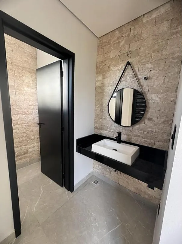 Lavabo com parede de pedra e cuba de apoio